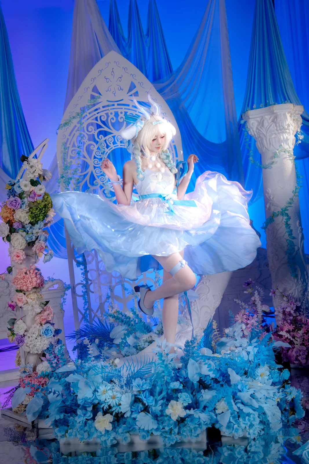 White-haired figure with crystal horns, skirt in motion, on a blue flower set