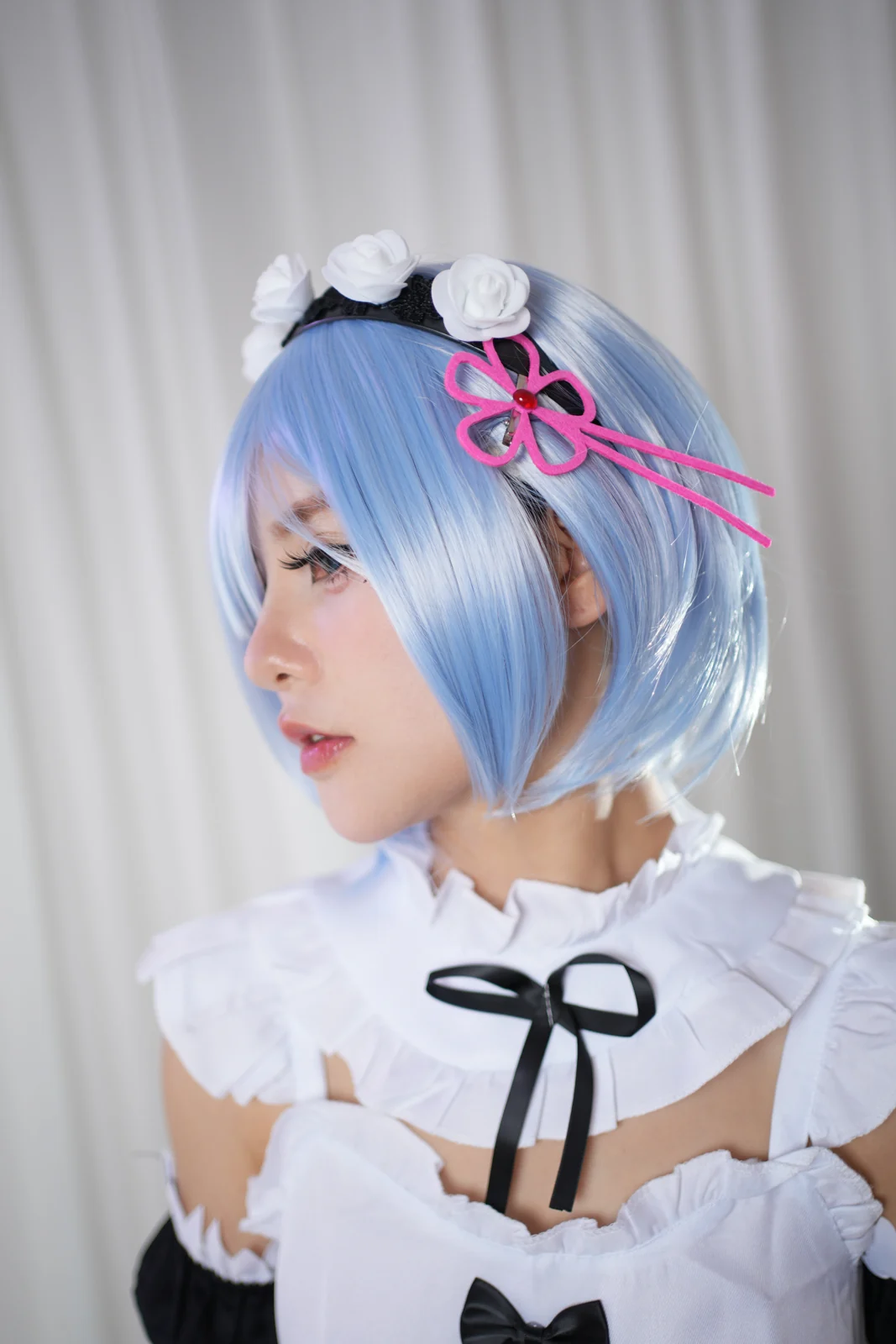 Close profile portrait with short blue hair, white roses and a maid collar